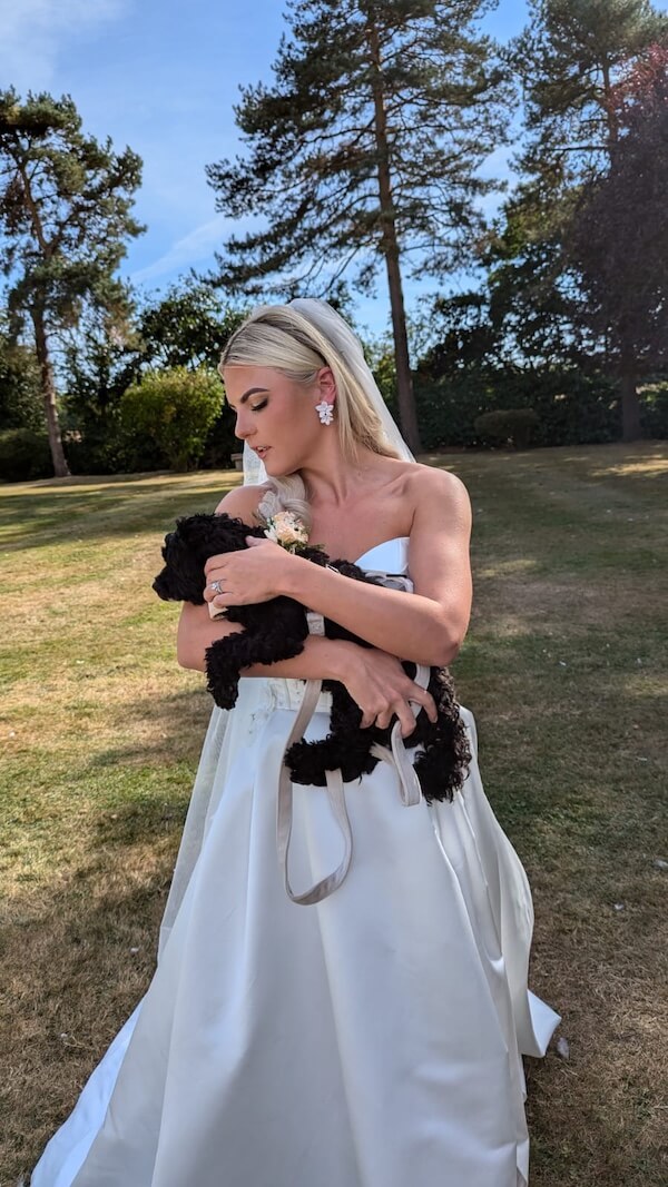 Bride standing up holding her dog