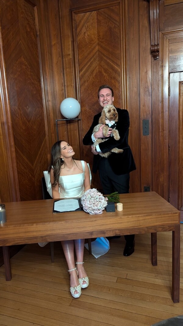 Wedding couple laughing whilst holding their dog