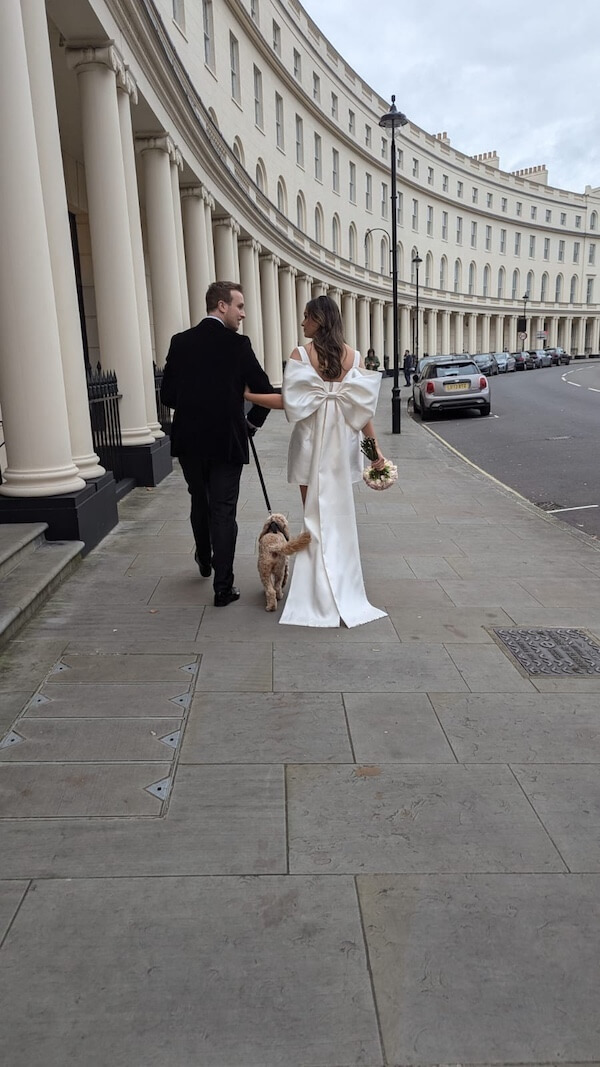 Wedding couple walking down the street with their dog